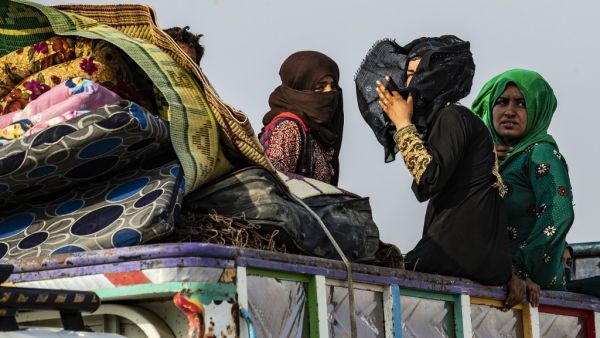 Syrians flee with their belongings the countryside of the northeastern Syrian town of Ras al-Ain on the Turkish border, toward the west to the town of Tal Tamr (AFP)