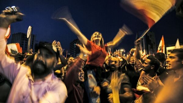 Lebanese protesters wave national flags as they attend a demonstration on the sixth day of protest against tax increases and official corruption, at Nur Square in Lebanon's northern port city of Tripoli (AFP)