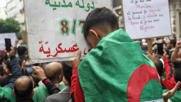 An Algerian boy rests his head on a placard that reads in Arabic "(we want) a civil state", during the 36th consecutive Friday anti-government demonstrations in the capital Algiers, on October 25, 2019. AFP