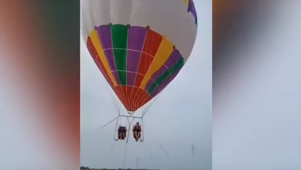 The footage shows the mother and her son sitting side by side and secured with harnesses beneath the large helium balloon. (Video Screenshot)