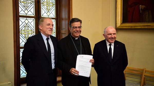 Francois Pinault, along with his son Francois-Henri Pinault (left and right) officially signed documents setting aside 100 million euros ($109 million) to reconstruct the flame-ravaged building. (AFP/ File Photo)
