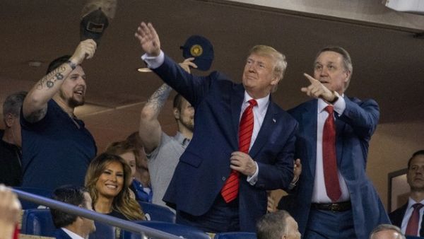 President Donald Trump (C) accompanied by Senator David Perdue (R-GA) (R) and a member of the military stand as members of the military are recognized during Game 5 of the World Series between the Washington Nationals and Houston Astros at Nationals Park in Washington, DC on October 27, 2019. (Tasos Katopodis/AFP)