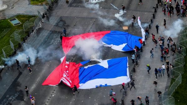 Demonstrators in Santiago carried a torn Chilean flag on October 25, 2019, as sometimes violent protests over both political and economic demands showed little sign of abating. (AFP/ File Photo)