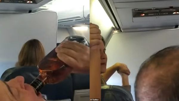 A male passenger drinks from a bottle of whisky after customers on board were notified that the aircraft had engine issues. (Twitter)