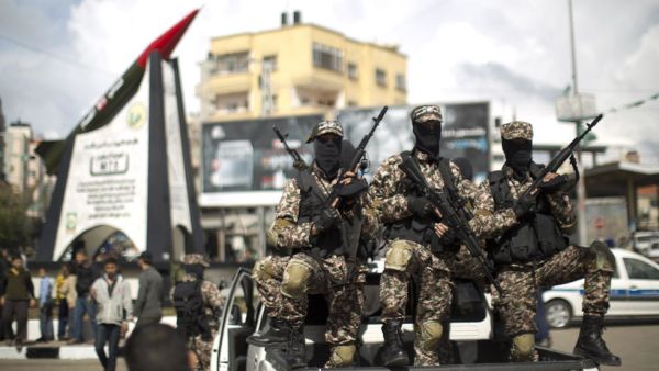 Members of Hamas's military wing pose in front of a M-75 rocket in Gaza. (AFP/ File Photo)