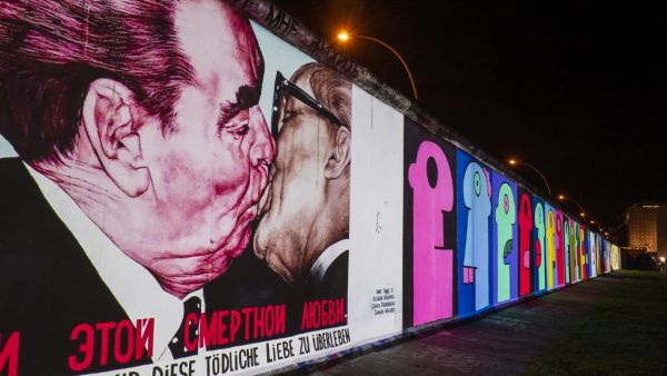 The mural painting "My God, Help Me to Survive This Deadly Love" by Russian painter Dmitri Vrubel, depicting the kiss between then Soviet leader Leonid Brezhnev (L) and East German leader Erich Honecker is projected on a stretch of the Berlin wall at the so-called East-side Gallery during the city-wide kick-off of the festival week to celebrate the 30th anniversary (AFP)
