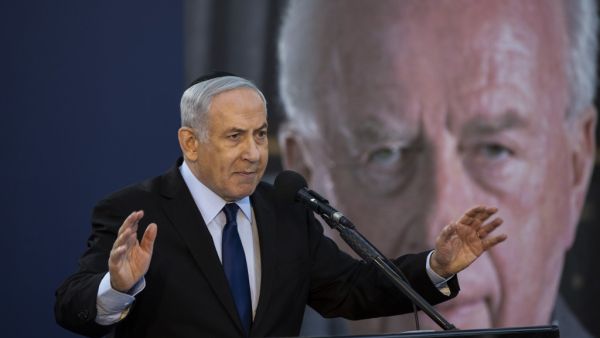 Israeli Prime Minister Benjamin Netanyahu speaks during a state memorial ceremony for former Israeli prime minister Yitzhak Rabin (backround) and his wife Leah, at Mount Herzl in Jerusalem on November 10, 2019.  (HEIDI LEVINE / POOL / AFP)
