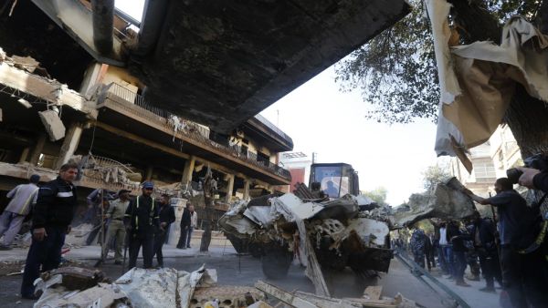 Syrian municipality workers clearing debris from building in Damascus' Mazze neighbourhood following an air strike (AFP)