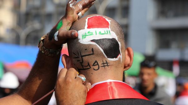 An Iraqi protester has a slogan reading in Arabic: "we need a country" paintend on his head during ongoing anti-government demonstrations on November 13, 2019 at Tahrir square in Baghdad. (SABAH ARAR / AFP)