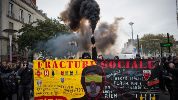 A demonstrator holds a smoke generator during a demonstration marking the first anniversary of the "yellow vest" (gilets jaunes) movement on November 16, 2019, in Nantes, western France. (LOIC VENANCE / AFP)