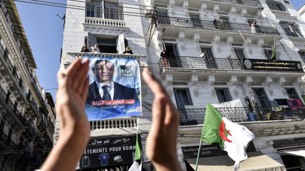 A supporters of Abdelkader Bengrina, former Algerian tourism minister and presidential candidate for the El-Bina (Construction) Islamist party, applauds outside his electoral campaign headquarters in the capital Algiers on November 17, 2019. (RYAD KRAMDI / AFP)