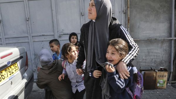 Women attempt to protect school children as they attempt to flee while stuck in clashes surrounding a demonstration demonstration by Israel's controversial separation barrier (AFP)