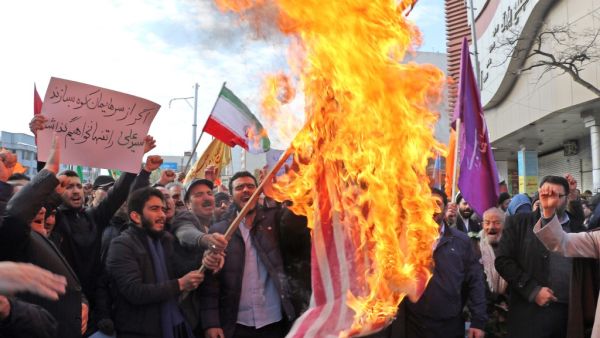 Iranian men burn a US flag during a protest in support of the Islamic republic's government and supreme leader, Ayatollah Ali Khamenei, in the northwestern city of Ardabil on November 20, 2019, as President Hassan Rouhani said the country's people had defeated an "enemy conspiracy" behind a wave of violent street protests. (AFP/ File Photo)