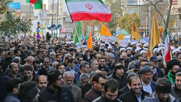 Iranians wave a national flag (R) during a protest in support of the Islamic republic's government and supreme leader, Ayatollah Ali Khamenei, in the northwestern city of Ardabil on November 20, 2019 (AFP/ File Photo)