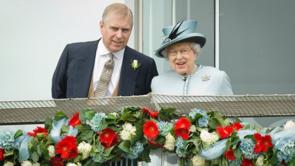 Prince Andrew, the Duke of York (L) speaks to Queen Elizabeth II on the Queens stand during Derby day at the Epsom Derby Festival, in Surrey, southern England, on June 1, 2013. (AFP/ File Photo)