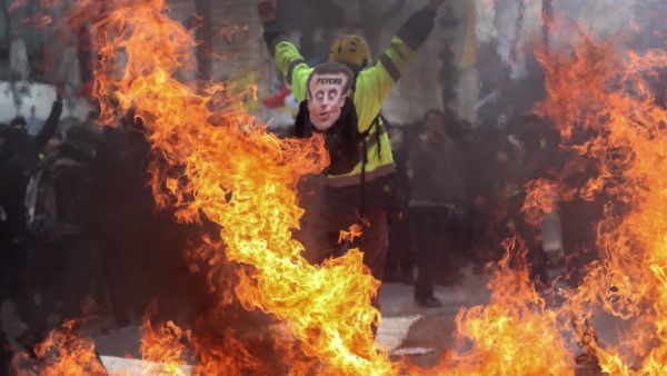 A Yellow Vest protester wearing a mask depicting the French President  (AFP)