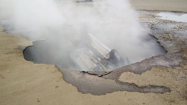 Steam engulfs the car inside the hole in Penza today. 'What an horrendous way to die - one moment you are driving a car, the next underground drowning in hot water,' said one woman. (EMERCOM)