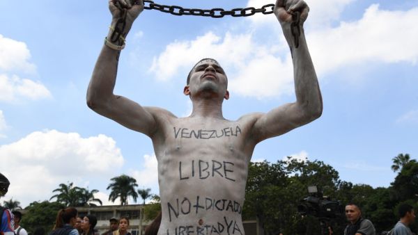 A university student holds a chain with his body painted during a protest against Venezuela's President Nicolas Maduro in Caracas on November 21, 2019. (Yuri CORTEZ / AFP)