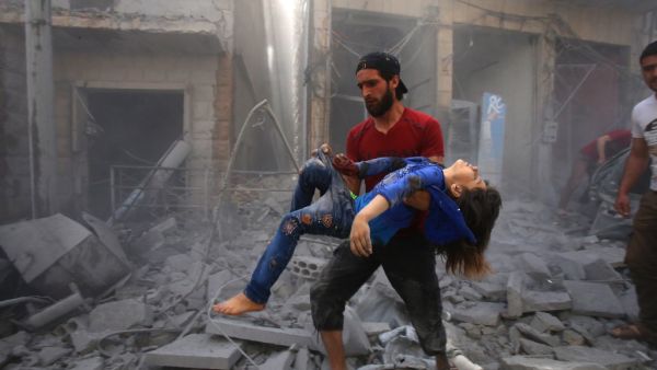 A man evacuates a young bombing casualty after a reported air strike by regime forces and their allies in the jihadist-held Syrian town of Maaret Al-Noman in the southern Idlib province, on May 26, 2019. (AFP/ File Photo)