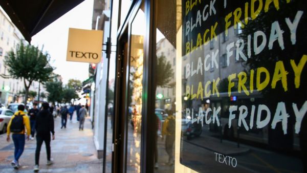 People walk past a showcase with a "Black Friday" logo on a banner in Ajaccio, on the French Mediterranean island of Corsica, on November 29, 2019 . PASCAL POCHARD-CASABIANCA / AFP