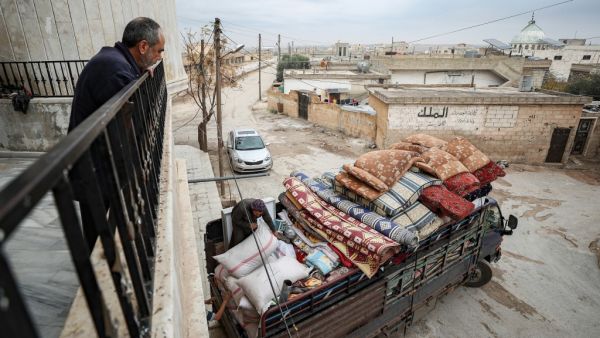 Abu Bilal, a Syrian man from the village of al-Ghadfah in Syria's northwestern Idlib province, watches from a balcony as a truck is being loaded with his belongings on December 1, 2019, before departing from the village towards Azaz in the north of Aleppo province following recent military developments in Idlib. (Omar HAJ KADOUR / AFP)