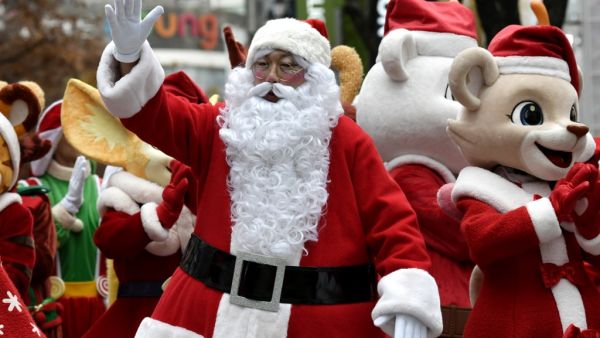 A performer clad in Santa Claus outfits poses during a street event to promote Christmas season at a shopping district in Seoul on December 3, 2019. (AFP/ File Photo)