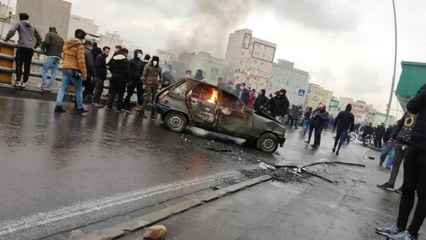 Iranian protesters gather around a burning car during a demonstration against an increase in gasoline prices in the capital Tehran, on November 16, 2019. (AFP/File)