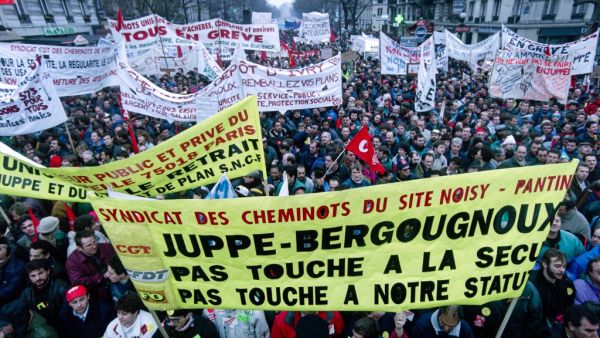People hold banners during a demonstration against French Prime Minister Alain Juppe's welfare reform plan continue in Paris on December 12, 1995. JOEL ROBINE / AFP