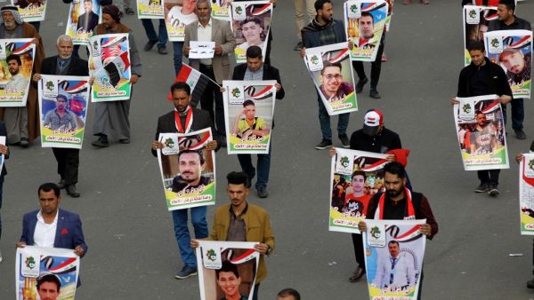 Iraqis hold pictures of killed demonstrators in the capital Baghdad's Tahrir Square, amid ongoing anti-government protests, on December 6, 2019. Tahrir has become a melting pot of Iraqi society, occupied day and night by thousands of demonstrators angry with the political system in place since the aftermath of the US-led invasion of 2003 and Iran's role in propping it up. AHMAD AL-RUBAYE / AFP