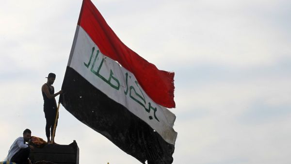 An Iraqi demonstrator waves a large national flag in the capital Baghdad's Tahrir Square, amid ongoing anti-government protests, on December 6, 2019. AFP