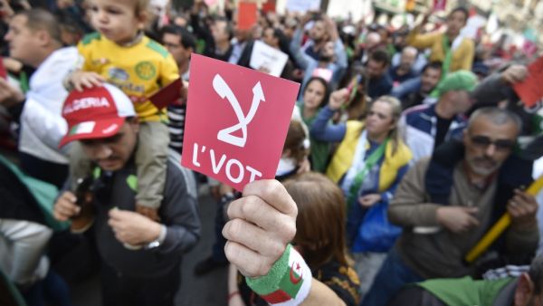 An Algerian demonstrator raises a red card that reads "No" in Arabic, referring to the upcoming presidential elections, during a rally in the capital Algiers on December 6, 2019. RYAD KRAMDI / AFP
