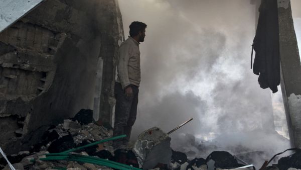 A man stands before a cloud of dust amidst rubble in a collapsed building following a reported air strike in the village of Balyun in Syria's northwestern Idlib province on December 7, 2019.  (AFP/ File Photo)