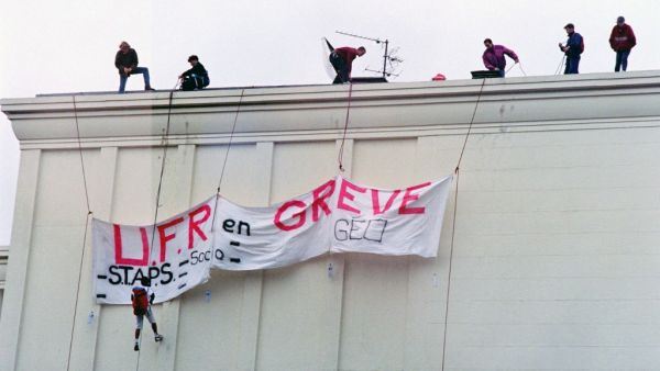 Demonstrators deploy a banner saying "UFR on strike", on the roof of a building, on November 12, 1995, in Caen, during the national strike movement against several cuts by the government in the welfare and pensions systems. Mychele DANIAU / AFP