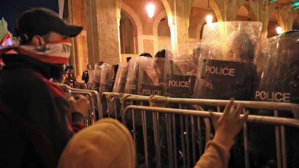 Lebanese demonstrators confront security forces in the capital Beirut on December 15, 2019. Lebanese police clashed with anti-government protesters in Beirut late Sunday, firing tear gas to prevent them from breaching barricades near parliament, ANWAR AMRO / AFP