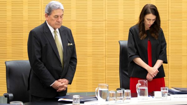 New Zealand Prime Minister Jacinda Ardern (C) and Deputy Prime Minister Winston Peters stand with cabinet ministers as they observe a minute's silence in respect for victims of the December 9 White Island volcanic eruption, at Parliament in Wellington on December 16, 2019. (AFP/ File Photo)