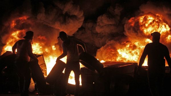 Protesters set aflame dumpsters and tires as they block a road in the southern Lebanese city of Sidon early on December 17, 2019. Mahmoud ZAYYAT / AFP