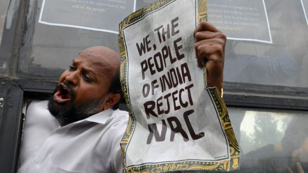 A protester shouts slogans from a bus after being taken into custody by police at the Town Hall during a demonstration held against India's new citizenship law in spite of a curfew in Bangalore (AFP)