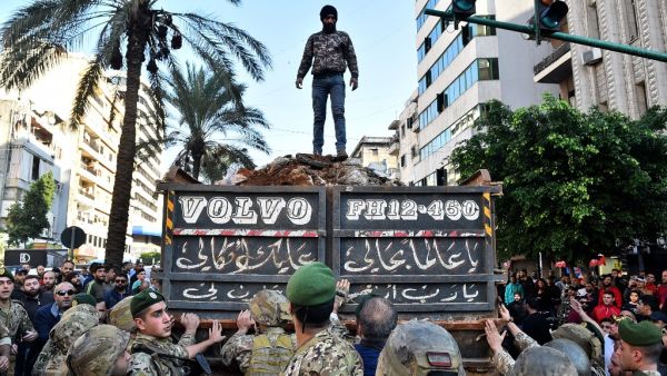 A supporter of outgoing Lebanese premier Saad Hariri stands atop a truckload of dirt during a protest in Beirut's Corniche al-Mazraa neighbourhood on December 20, 2019. Anger was fuelled among members of Lebanon's Sunni community who said the prime-minister-designate did not enjoy the sect's backing for a post reserved for Sunni Muslims by a power-sharing system enshrined after the end of the 1975-1990 civil war. STR / AFP