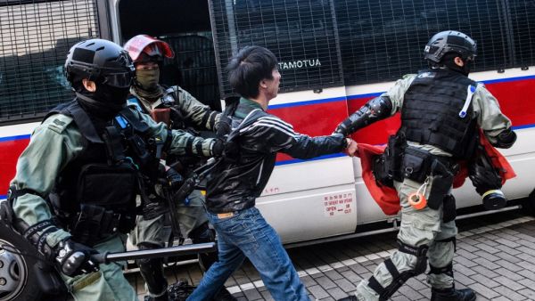Police detain a man during a rally in Hong Kong on December 22, 2019 to show support for the Uighur minority in China. Hong Kong riot police broke up a solidarity rally for China's Uighurs on December 22 -- with one officer drawing a pistol -- as the city's pro-democracy movement likened their plight to that of the oppressed Muslim minority. Anthony WALLACE / AFP