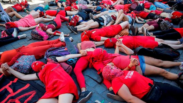 Activists lie on the ground in the Chilean capital and hold hands in solidarity against social and economic inequality affecting women  (AFP)