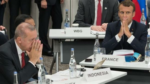 Turkey's President Recep Tayyip Erdogan (L) and his French counterpart Emmanuel Macron gesture as they attend a meeting on the digital economy at the G20 Summit in Osaka, Japan, June 28, 2019. (Photo by AFP)