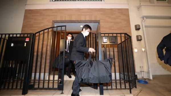 Japanese prosecutors carry bags as they leave the residence of former auto tycoon Carlos Ghosn on January 2, 2020, after Ghosn fled Japan to avoid a trial. Former Nissan boss Carlos Ghosn, who fled to Lebanon to avoid a Japanese trial, had a second French passport, a source said on January 2, as authorities raided his Tokyo residence as part of a probe into the embarrassing security lapse. STR / JIJI PRESS / AFP