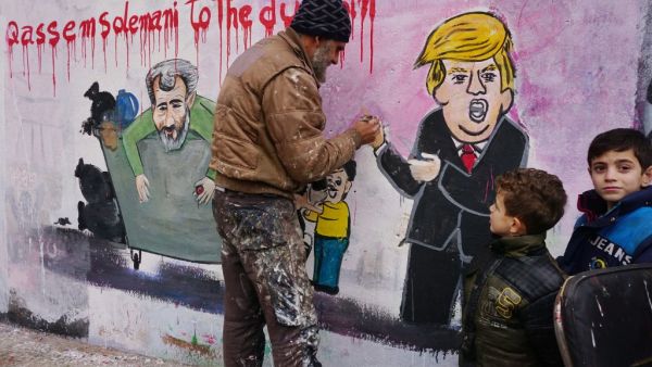 Anis Hamdoun, one of two Syrian painters who completed a mural on January 3, 2020 following the killing of Iranian Revolutionary Guards commander Qasem Soleimani puts the final touches on his creation in the town of Binnish in the northwestern Idlib province. AFP