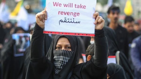 An Iraqi woman holds a placard during the funeral of Iranian military commander Qasem Soleimani, Iraqi paramilitary chief Abu Mahdi al-Muhandis and eight others in Baghdad's district of al-Jadriya, in Baghdad's high-security Green Zone, on January 4, 2020. (AFP/ File Photo)