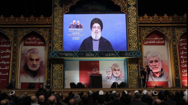 Supporters of the the Shiite Hezbollah movement watch as the movement's leader Hasan Nasrallah delivers a speech on a screen, in the Lebanese capital Beirut's southern suburbs on January 5, 2020. Nasrallah called on Iraq to free itself of the American "occupation" after top Iranian general Qasem Soleimani was killed in a US strike in Baghdad. ANWAR AMRO / AFP
