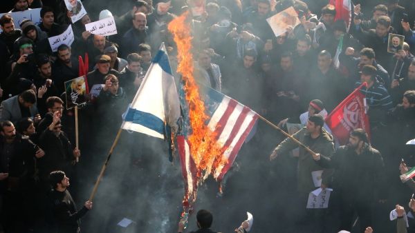 Iranians set a US and an Israeli flag on fire during a funeral procession organised to mourn the slain military commander Qasem Soleimani, Iraqi paramilitary chief Abu Mahdi al-Muhandis and other victims of a US attack in the capital Tehran on January 6, 2020. (AFP/ File Photo)