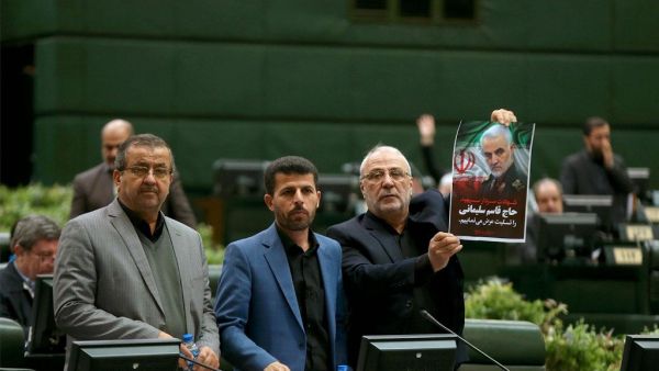 This handout picture provided by the Islamic Consultative Assembly News Agency (ICANA) shows an Iranian lawmaker holding a picture of slain top general Qasem Soleimani as he votes during a parliamentary session in Tehran.  (AFP/ File Photo)