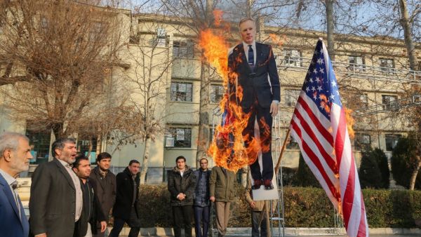 Members of the Basij, a militia loyal to the Islamic republic's establishment, burn a cardboard cutout of Britain's ambassador Rob Macaire along a Union Jack and US flag during a memorial for victims of the Ukraine plane crash, at University of Tehran on January 14, 2020. Iran signalled it could expel Britain's ambassador in case of further "interference" in its affairs after a row over a vigil he attended for those killed in last week's downing of a Ukrainian plane. ATTA KENARE / AFP
