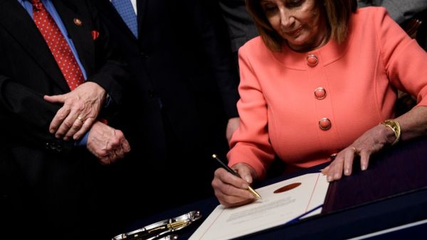 Speaker of the House Nancy Pelosi (D-CA) signs the articles of impeachment of US President Donald Trump during an engrossment ceremony on Capitol Hill January 15, 2020, in Washington, DC. The US House of Representatives voted Wednesday to transmit articles of impeachment against President Donald Trump to the Senate, opening the way for the historic trial of the 45th president for abuse of power. Brendan Smialowski / AFP