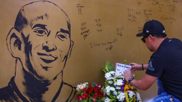 A fan places flowers to mourn former Los Angeles Lakers basketball player Kobe Bryant following his death overnight in the US, near the "House of Kobe" gym built in honour of his 2016 visit to the Philippines, in Manila on January 27, 2020. Maria TAN / AFP